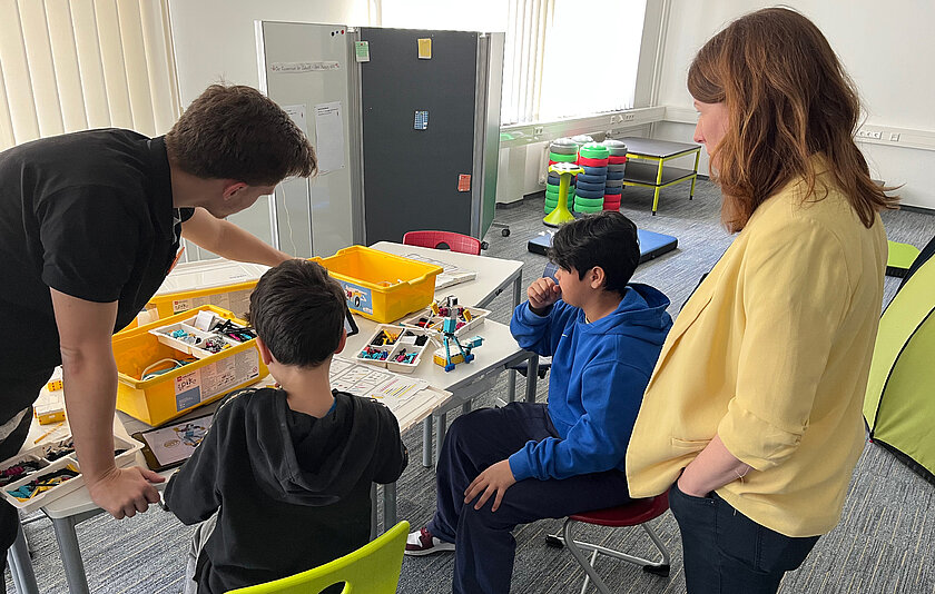 Anna Christmann sowie ein Pädagoge des Stadtmedienzentrums und Schüler im Makerspace Stuttgart