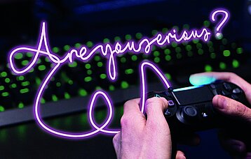 Hände, Gerät und Neonschriftzug vor Tastatur