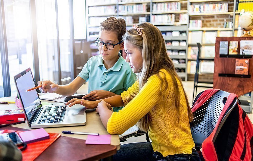 Junge und Mädchen lernen gemeinsam am Laptop
