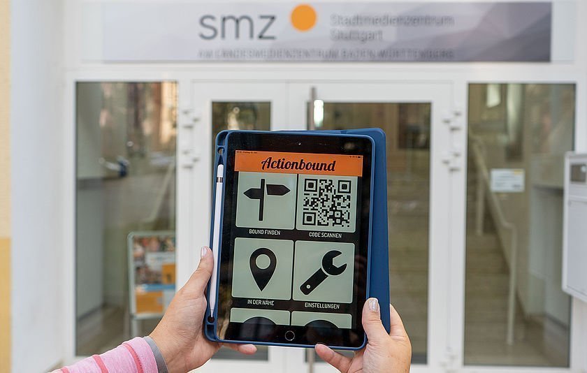 Tablet in Händen vor Eingangstür