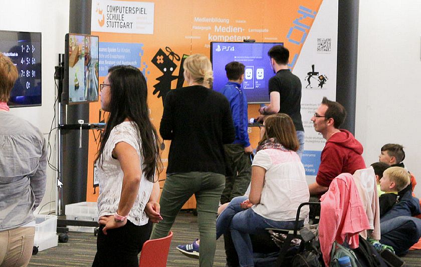 Besucherinnen und Besucher im Foyer vor Bildschirmen